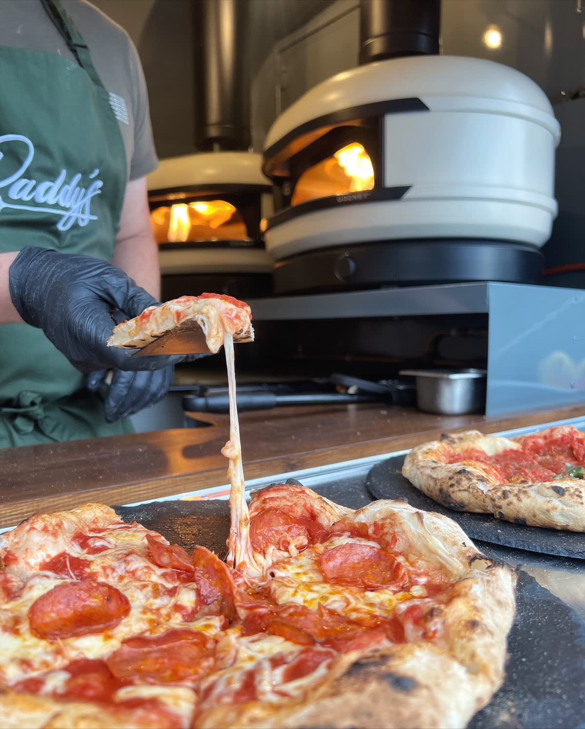 Paddy's Pizza catering team serving wood-fired pizza